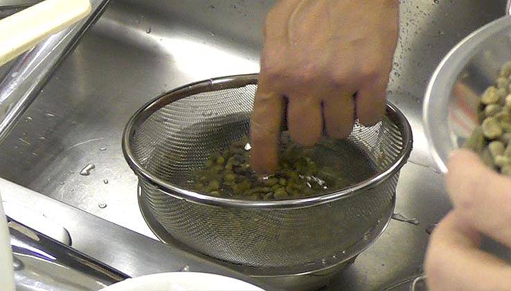 洗った豆をザルに入れる